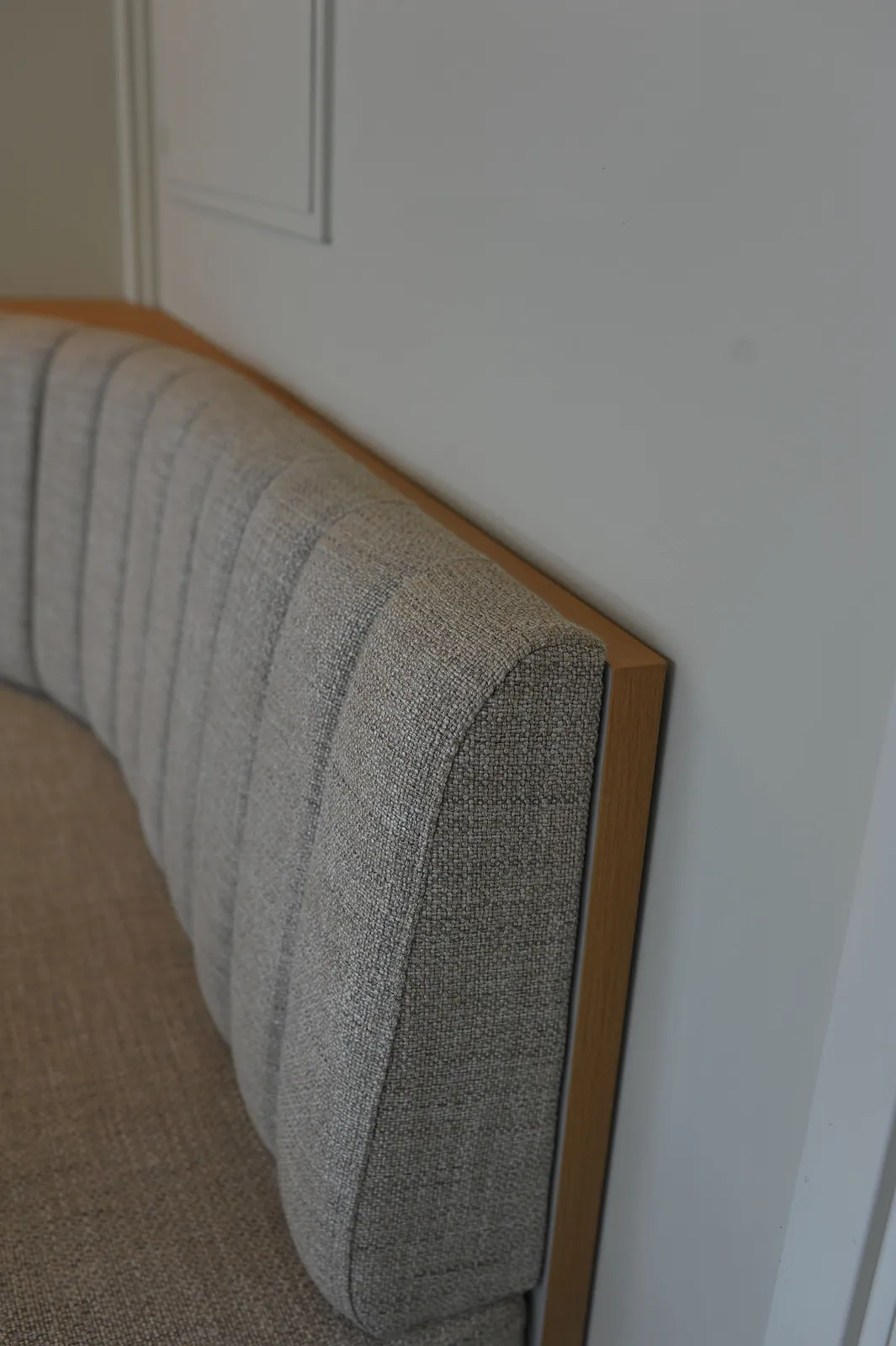 Detalj av sofabenk med stoppet rygg og avslutning i eik